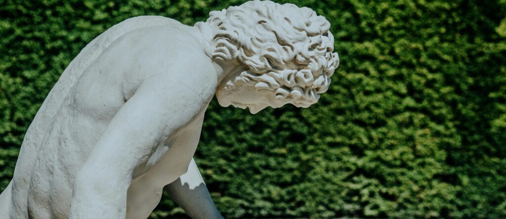 Stunning marble statue set against vibrant greenery in a Parisian garden, capturing timeless artistry.
